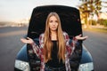 Car breakdown, sad female driver against open hood Royalty Free Stock Photo