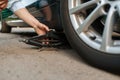 Car breakdown, male person repairing flat tyre