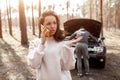 The car broke down. The guy is trying to fix the car. A young woman calls and asks for help in service services Royalty Free Stock Photo