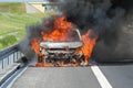 A car burning on a highway with thick black smoke Royalty Free Stock Photo