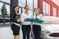 Car buy procedure. Woman dealer with tablet and buyers with folder standing near car Royalty Free Stock Photo