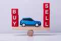 Car Between And Buy And Sell Balancing On Seesaw Royalty Free Stock Photo