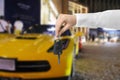 Car buying. Man holding key against automobile, closeup Royalty Free Stock Photo