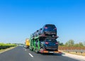 Car carrier trailer with cars on bunk platform. Car transport truck on the highway. Space for text Royalty Free Stock Photo