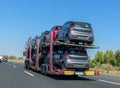 Car carrier trailer with cars on bunk platform. Car transport truck on the highway Royalty Free Stock Photo