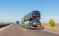 Car carrier trailer with cars for sale on bunk platform on the highway Royalty Free Stock Photo