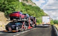 A car carrier trailer, known variously as a car-carrying trailer, car hauler, auto transport trailer, on a beautiful road