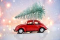 Car carrying a Christmas tree on a festive background. Merry Christmas and Happy New Year Postcard