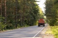 A car carrying a dangerous cargo rides on the road through the forest