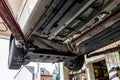 Car chassis on the lift, view from the bottom. Visible exhaust system, wheels, brake hoses. Royalty Free Stock Photo