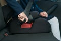 In the car, the child`s hand fastens the seat belt while sitting in the child seat