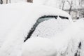 Car completely covered with snow, blocked and does not open. Dangerous road conditions. Cleaning cars from ice, selective focus