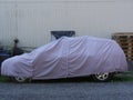 Car covered with cover in the backyard