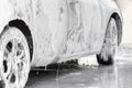 The car is covered with foam at a self-service car wash. Man washes foam machine. Carwash. Washing machine at the station Royalty Free Stock Photo