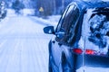 Car covered with snow on a dangerous road.