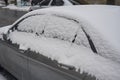 Car covered with snow,there is snow on a gray car parked on the side of the street