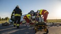 On the Car Crash Traffic Accident Scene: Paramedics Saving Life of a Female Victim who is Lying on Royalty Free Stock Photo