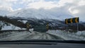 Car crossing a narrow single-lane bridge on a icy rural road between Fagernes and Brevikeidet, Norway with snow-covered mountains. Royalty Free Stock Photo