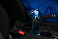 In a car in a cup holder there is a bottle of water, for the driver at the wheel