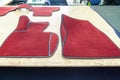 Car 3D handmade floor mats of red color from wool for front and rear passengers of a vehicle in an interior design workshop with Royalty Free Stock Photo