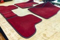 Car 3D handmade floor mats of red color from wool for front and rear passengers of a vehicle in an interior design workshop with Royalty Free Stock Photo