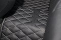 Car 3D handmade rugs with diamond-shaped stitching threads of black color from genuine leather for rear central tunnel of a Royalty Free Stock Photo