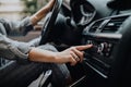 Car dashboard. Radio closeup. Woman sets up radio while driving car Royalty Free Stock Photo