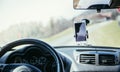 Car dashboard with smartphone used as navigation device, bright and sunny day