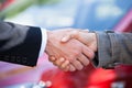 Car dealer and female client shaking hands at dealership Royalty Free Stock Photo