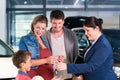 Car dealer giving key to new auto to family Royalty Free Stock Photo