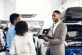 Car Dealer Man Selling Auto Talking With Customers In Dealership