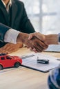 Car dealer or sales manager offers to sell a car and explains terms of car contract signing and insurance handshake