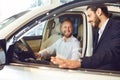 Car dealer showing automobile to client. Royalty Free Stock Photo