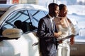 Car dealer showing vehicle to black woman Royalty Free Stock Photo