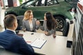 Car dealership manager making car purchase for happy lgbt couple