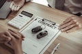 Car dealership or sales manager offers the sale of a car and explains the terms of signing a car purchase and insurance contract