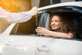 Car dealership. The woman sitting in the car and receiving car key with a smile from the salesman. Auto Leasing Business Royalty Free Stock Photo