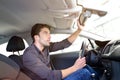 Car dealership - young handsome man sits in a car and buying a Royalty Free Stock Photo