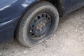 Car with deflated wheel on street. Old car with deflated wheel parked on street