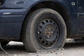 Car with deflated wheel on street. Old car with deflated wheel parked on street