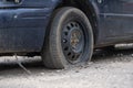 Car with deflated wheel on street. Old car with deflated wheel parked on street