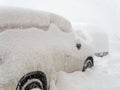 A car densely covered with snow stands in a snowdrift during heavy snowfall. Closeup photo Royalty Free Stock Photo