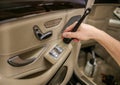 Male hand cleaning car interior upholstery with detail brush. Focus on brush. Royalty Free Stock Photo