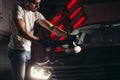 Car detailing - man with orbital polisher in auto repair shop. Selective focus. Royalty Free Stock Photo