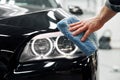 Car detailing - the man holds the microfiber in hand and polishes the car