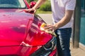 Car detailing - the man holds the microfiber in hand and polishes the car. Man worker washing car`s alloy wheels on a car wash. Royalty Free Stock Photo