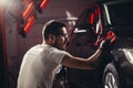 Car detailing - the man holds the microfiber in hand and polishes the car