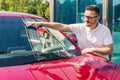 Car detailing - the man holds the microfiber in hand and polishes the car. Man worker washing car`s alloy wheels on a car wash. Royalty Free Stock Photo