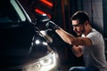 Car detailing - man with orbital polisher in auto repair shop. Selective focus. Royalty Free Stock Photo