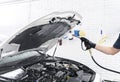 Car detailing. Manual car wash engine with pressure water. Washing car engine with water nozzle. Car washman worker cleaning vehic